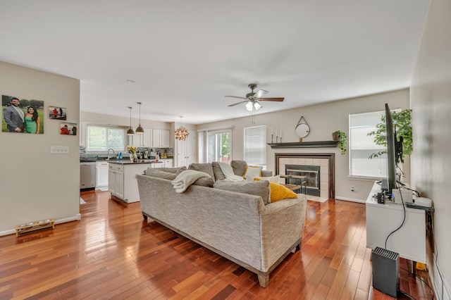 2704 Flagstone Cir, Naperville, IL 60564 - living area with light wood finished floors, a tile fireplace, baseboards, and a ceiling fan