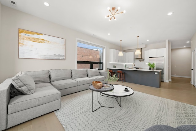 living room featuring visible vents, baseboards, recessed lighting, and a notable chandelier
