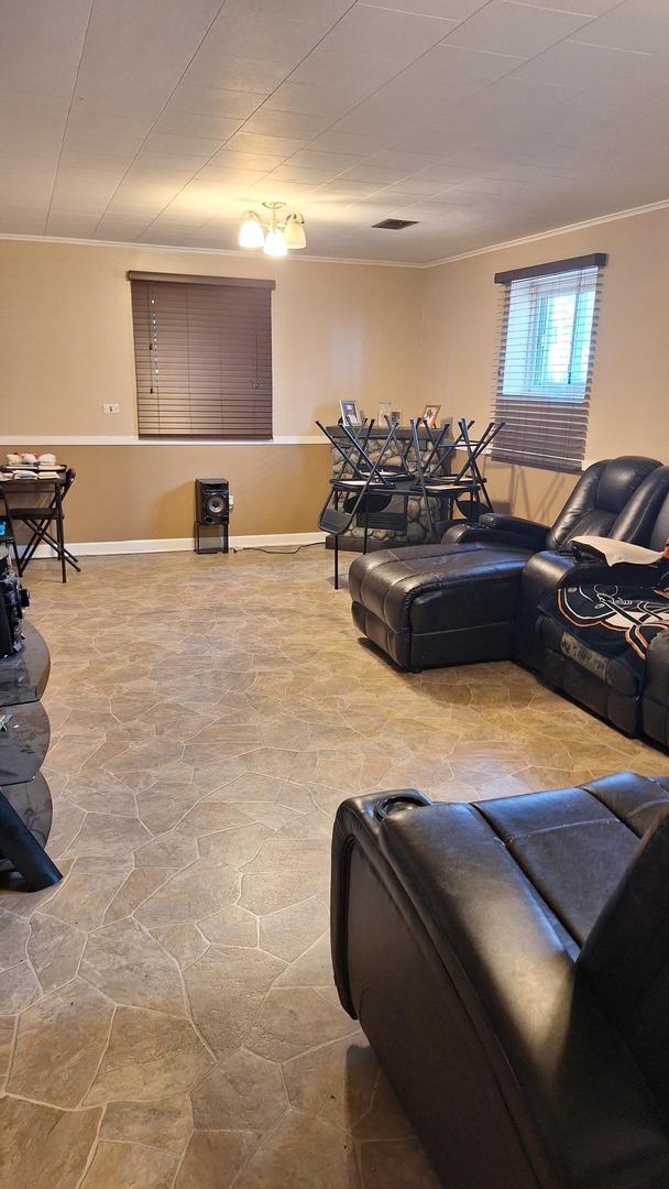 1344 Jeffery Dr, Homewood, IL 60430 - living area with stone finish flooring, baseboards, and crown molding