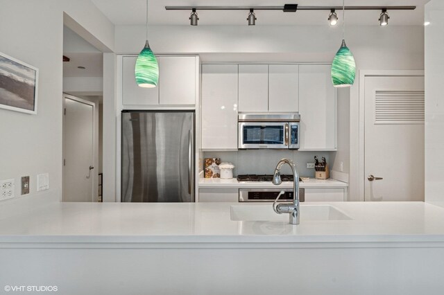 505 N Mcclurg Ct Unit 1801, Chicago, IL 60611 - kitchen featuring appliances with stainless steel finishes, white cabinetry, decorative light fixtures, track lighting, and light countertops