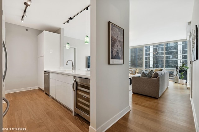 505 N Mcclurg Ct Unit 1801, Chicago, IL 60611 - bar area with wine cooler, a sink, light wood-style flooring, pendant lighting, and baseboards
