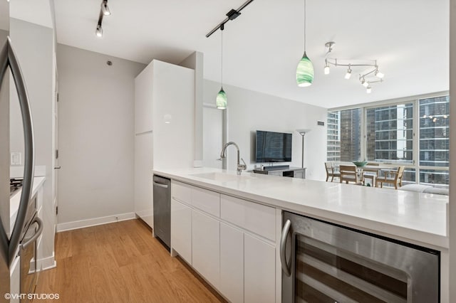 505 N Mcclurg Ct Unit 1801, Chicago, IL 60611 - kitchen featuring rail lighting, wine cooler, a sink, stainless steel dishwasher, and white cabinets