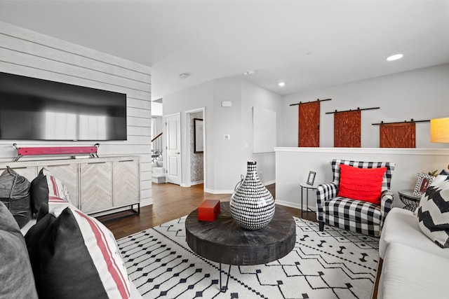 living area featuring stairs, a barn door, wood finished floors, baseboards, and recessed lighting