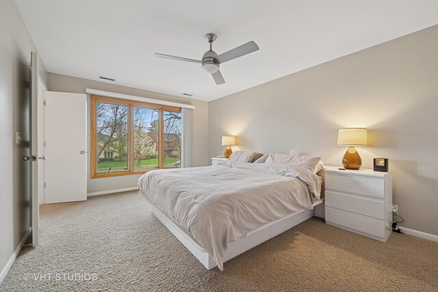 bedroom with baseboards, visible vents, ceiling fan, and light colored carpet