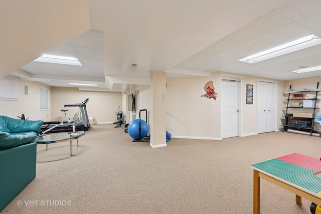 workout room featuring baseboards, a drop ceiling, and carpet flooring