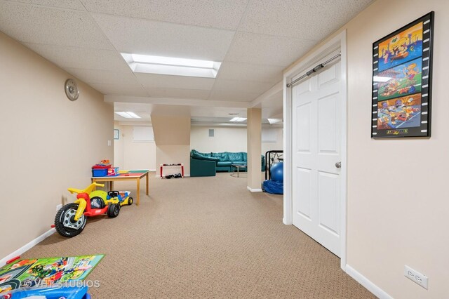 rec room featuring carpet floors, baseboards, and a drop ceiling