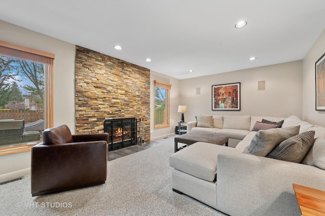 living area with recessed lighting, baseboards, visible vents, and a fireplace