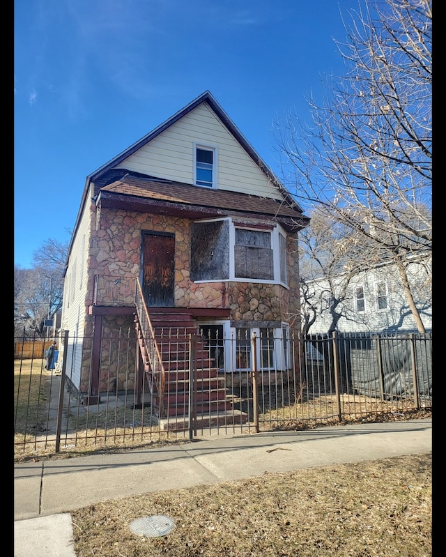 8418 S Colfax Ave, Chicago, IL 60617 - view of front facade featuring stone siding and a fenced front yard