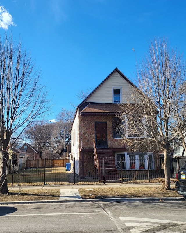 8418 S Colfax Ave, Chicago, IL 60617 - bungalow-style home with stone siding and a fenced front yard