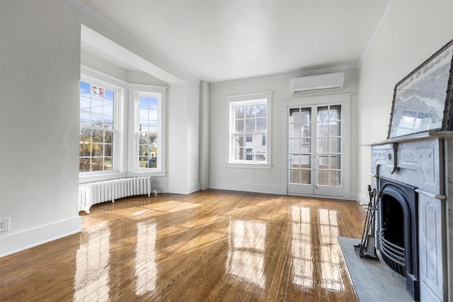 206 Franklin Pl, Rockford, IL 61103 - unfurnished living room with radiator heating unit, a wall mounted air conditioner, ornamental molding, hardwood / wood-style flooring, and a fireplace with flush hearth