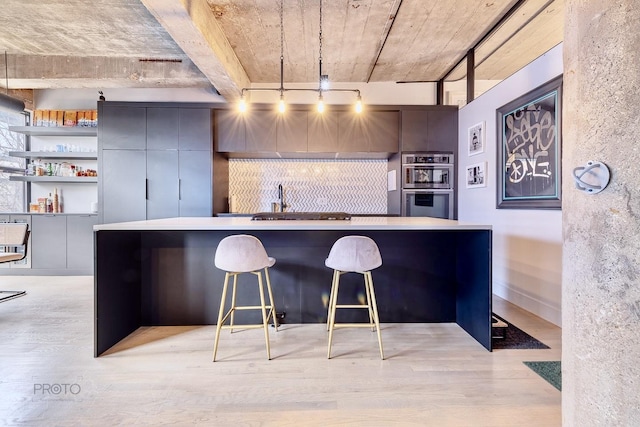 1070 W 15th St Unit 302, Chicago, IL 60608 - kitchen featuring stainless steel double oven, light wood-style flooring, a kitchen island, a breakfast bar area, and modern cabinets