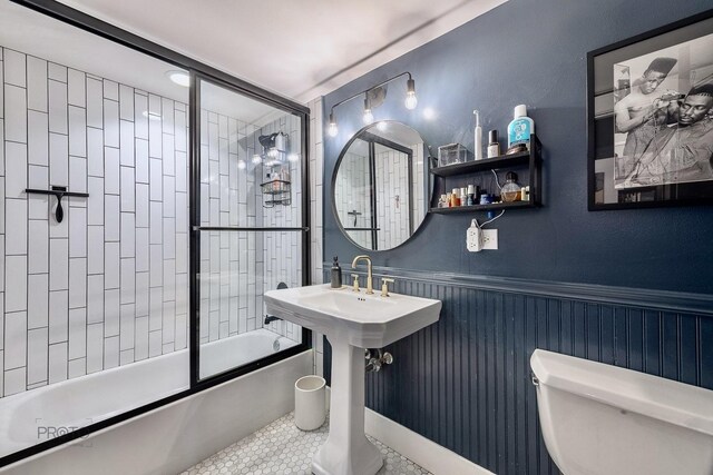 1070 W 15th St Unit 302, Chicago, IL 60608 - bathroom featuring toilet, tile patterned floors, bath / shower combo with glass door, and wainscoting