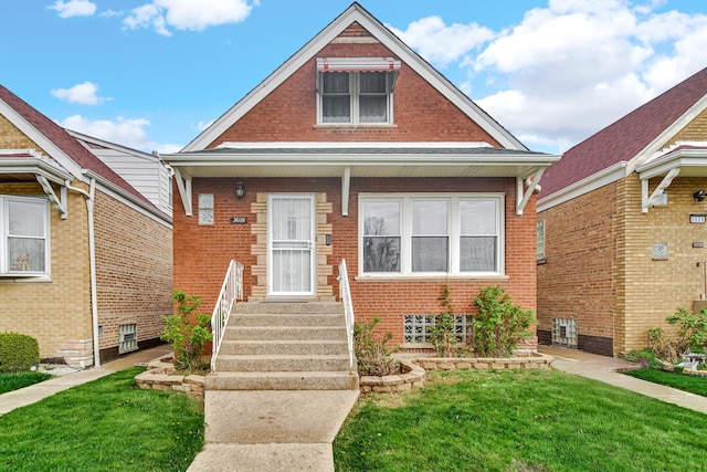 bungalow featuring a front lawn and brick siding