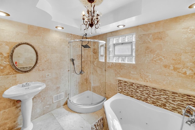 bathroom featuring a stall shower, tile walls, visible vents, and a jetted tub