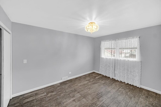 additional living space featuring wood walls, baseboards, wood finished floors, and visible vents