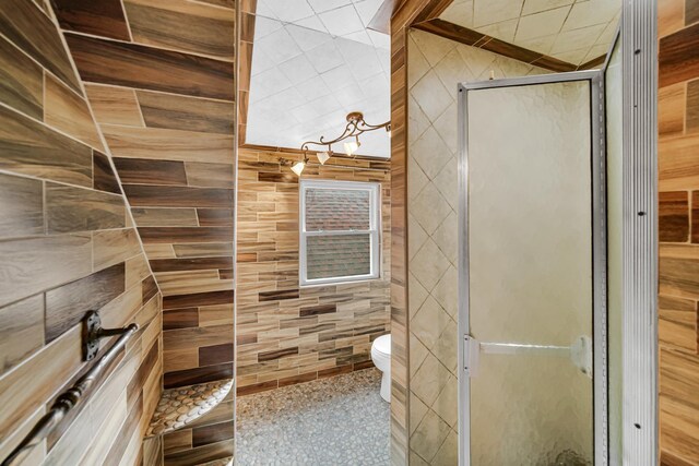 half bathroom featuring tile walls, a sink, and toilet