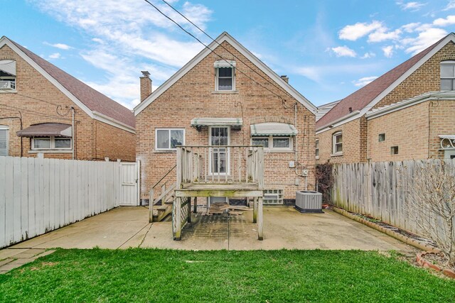 rear view of house featuring a fenced backyard, brick siding, and a patio