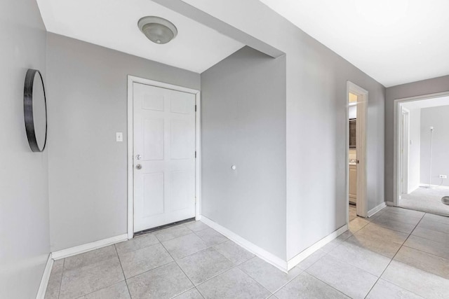entryway featuring baseboards and light tile patterned floors