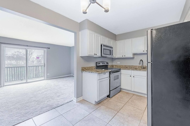 kitchen featuring white cabinets, light carpet, light tile patterned floors, and appliances with stainless steel finishes