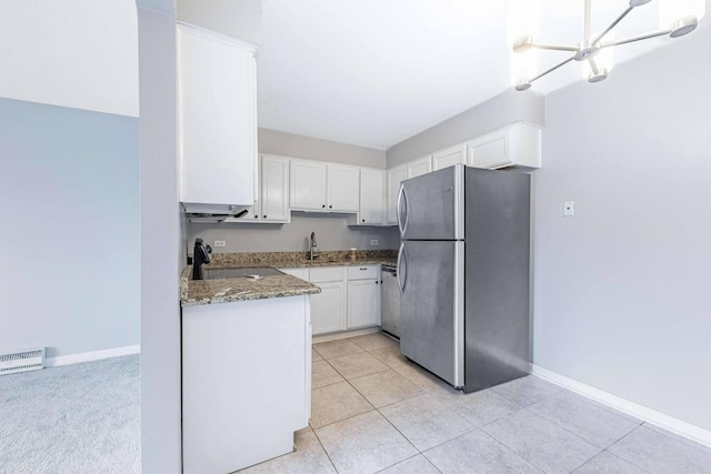 kitchen with a sink, stone counters, baseboards, white cabinetry, and appliances with stainless steel finishes