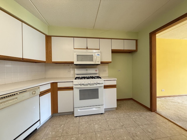 7120 N Milwaukee Ave Unit 305, Niles, IL 60714 - kitchen with white appliances, light countertops, a textured ceiling, white cabinetry, and decorative backsplash