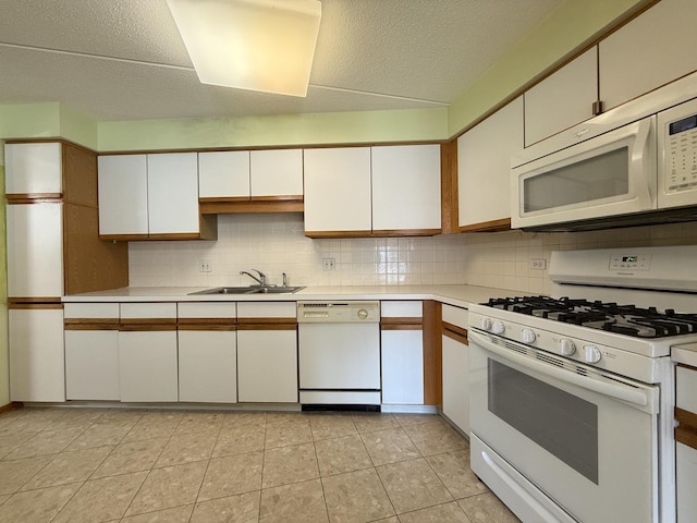 7120 N Milwaukee Ave Unit 305, Niles, IL 60714 - kitchen with white appliances, white cabinets, light countertops, a sink, and backsplash