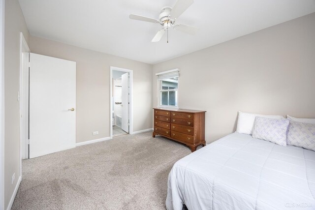 carpeted bedroom featuring baseboards, ceiling fan, and connected bathroom
