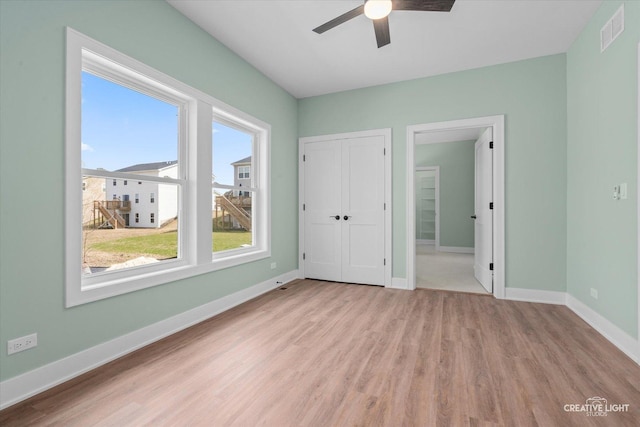 unfurnished bedroom featuring wood finished floors, visible vents, and baseboards