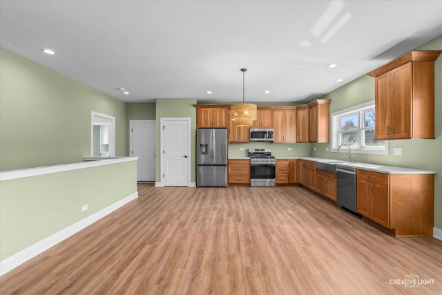 kitchen with light countertops, brown cabinetry, baseboards, light wood-style flooring, and appliances with stainless steel finishes