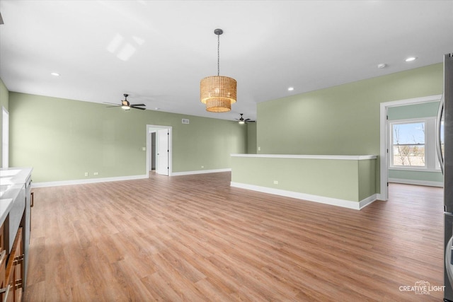 unfurnished living room featuring light wood finished floors, baseboards, recessed lighting, and ceiling fan