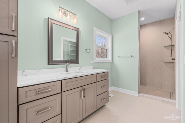 full bathroom with baseboards, vanity, and tiled shower
