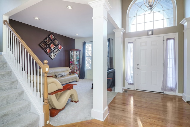foyer featuring wood finished floors, decorative columns, recessed lighting, and stairs