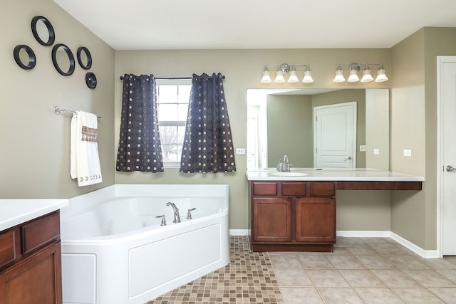 full bath featuring tile patterned floors, vanity, baseboards, and a tub with jets