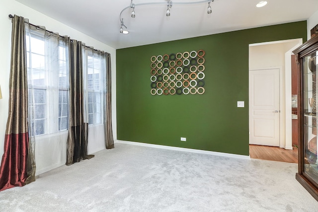 empty room featuring baseboards and carpet