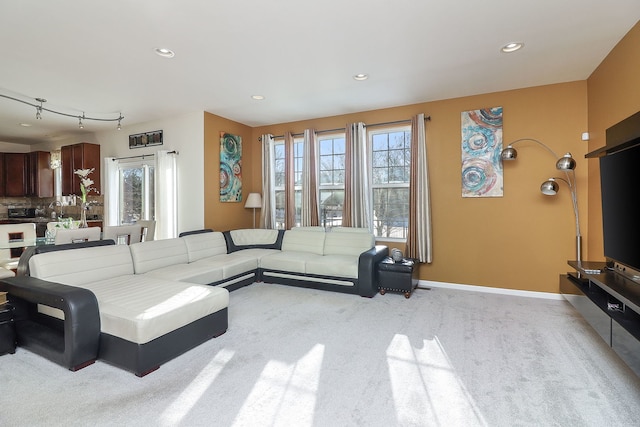 living room featuring baseboards, recessed lighting, plenty of natural light, and light carpet