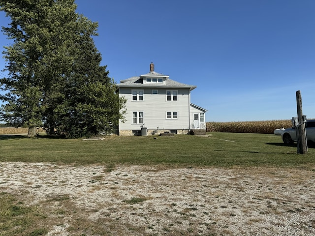 back of house with a yard and a chimney