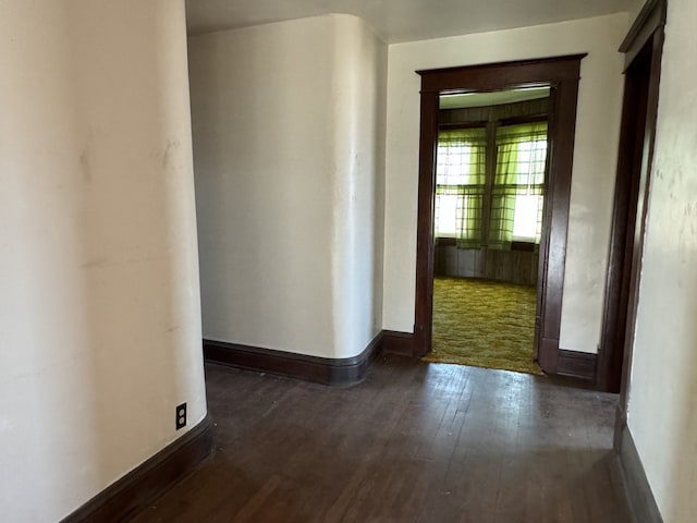 hallway featuring hardwood / wood-style floors and baseboards