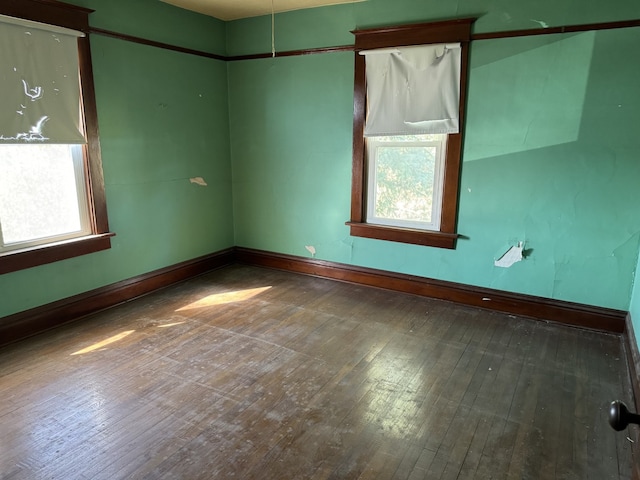 unfurnished room featuring baseboards and hardwood / wood-style flooring