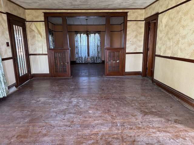 spare room featuring wallpapered walls and wood finished floors