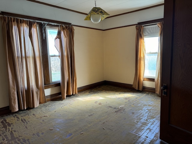 spare room featuring plenty of natural light, baseboards, and ornamental molding
