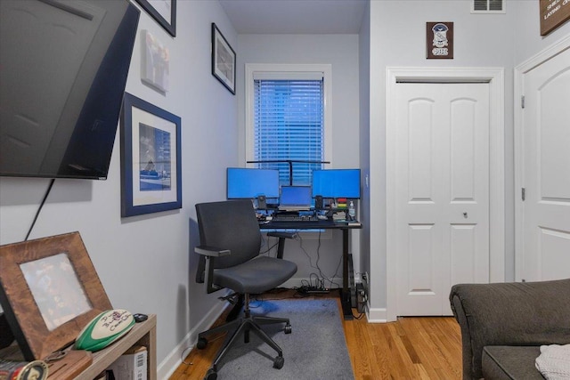 office featuring wood finished floors, baseboards, and visible vents
