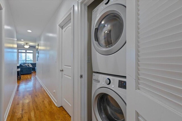 washroom featuring baseboards, stacked washer / dryer, laundry area, recessed lighting, and light wood finished floors