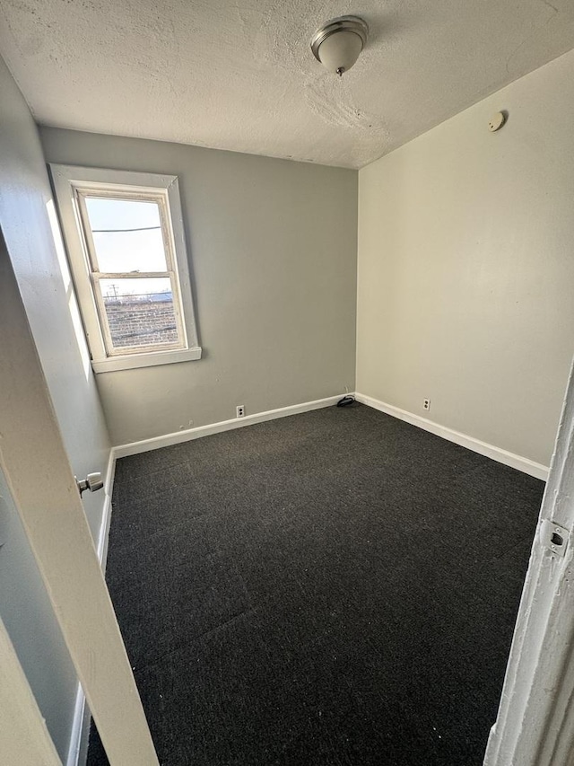 5015 N Kimberly Ave, Chicago, IL 60630 - spare room featuring dark carpet, baseboards, and a textured ceiling