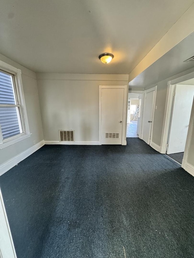 5015 N Kimberly Ave, Chicago, IL 60630 - empty room featuring dark carpet, visible vents, and baseboards