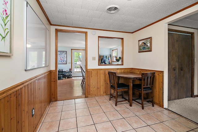 4618 W Hilltop Dr, Kankakee, IL 60901 - dining space featuring a wainscoted wall, crown molding, wooden walls, and light tile patterned flooring