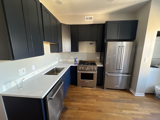 4909 N Avers Ave Unit 3, Chicago, IL 60625 - kitchen featuring premium appliances, a sink, light wood-style flooring, and baseboards