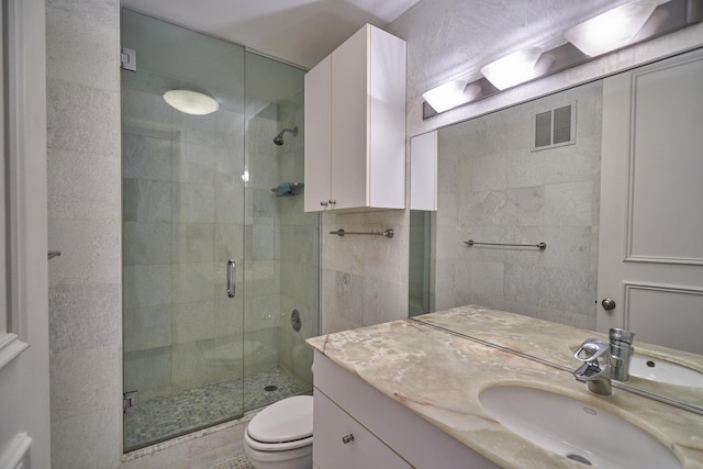 bathroom featuring a stall shower, vanity, and toilet