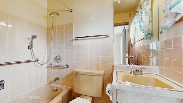 full bath with tile walls, vanity, toilet, and bathing tub / shower combination