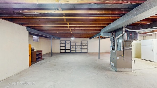 unfinished basement with freestanding refrigerator, heating unit, and stairs