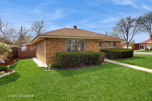 view of home's exterior featuring brick siding, a lawn, fence, and a chimney